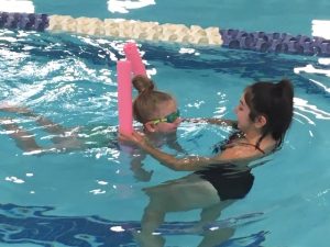 Swimmer and instructor in pool
