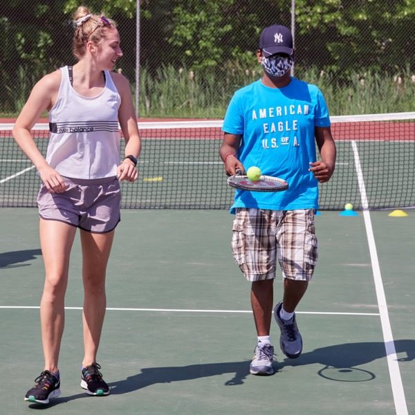 Student balancing ball on racket