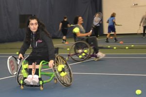 Woman in wheelchair playing tennis