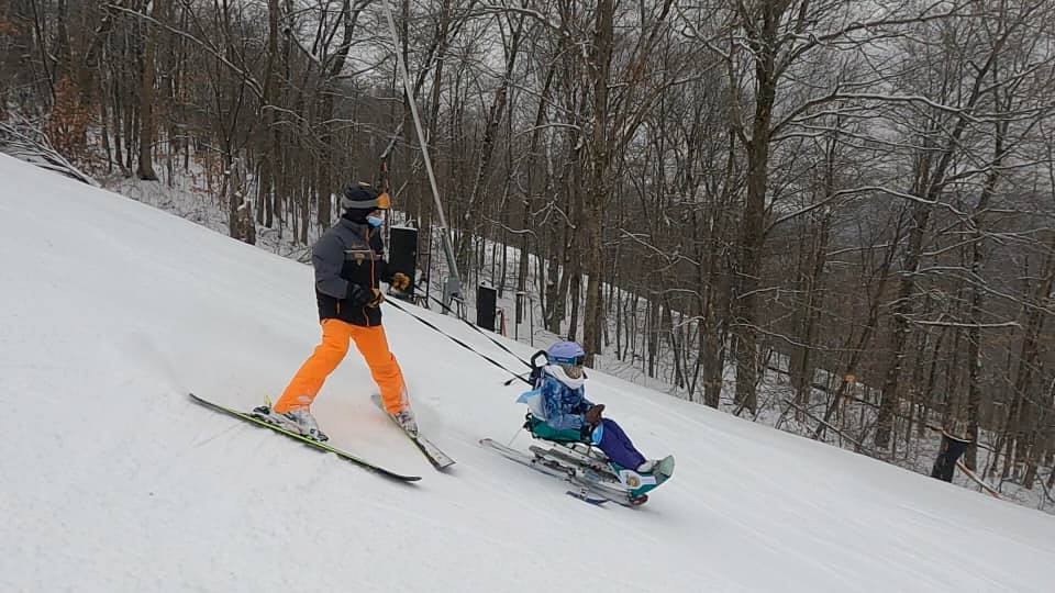 skiier and sled skiier heading down mountain together
