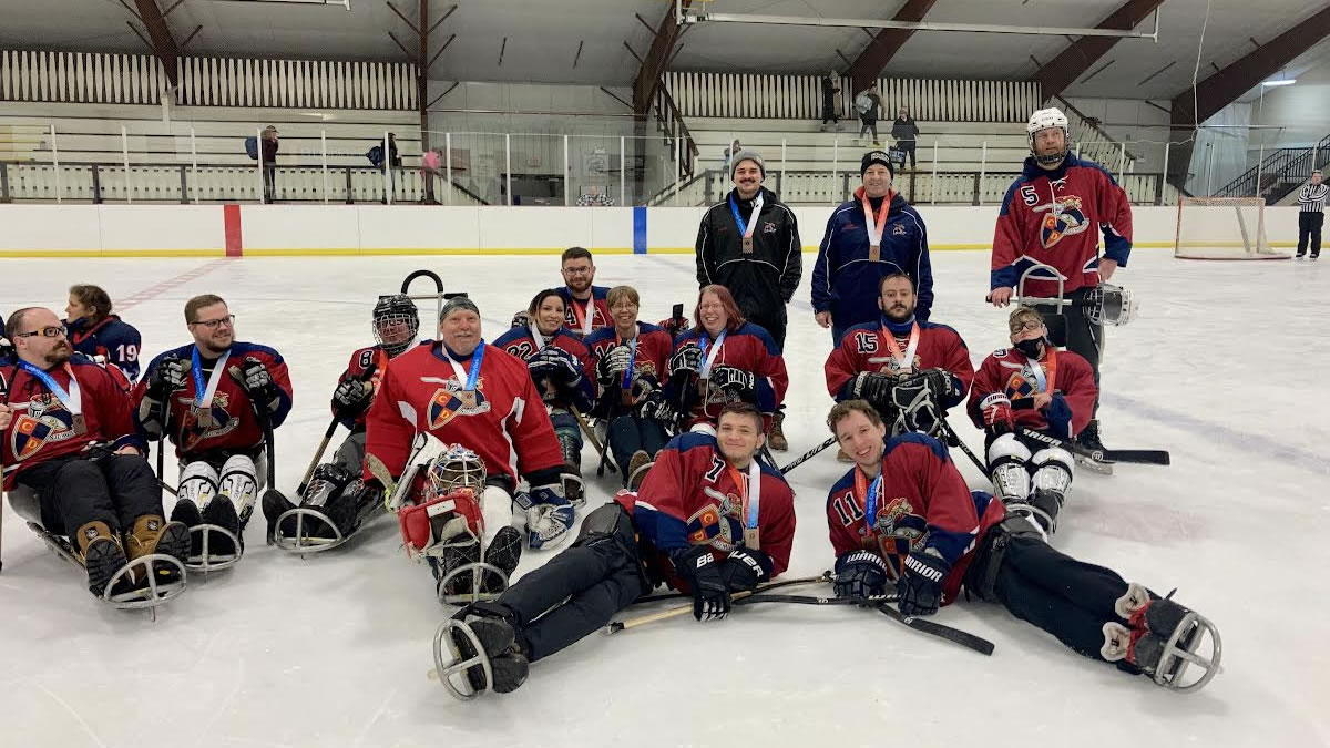 Sled Hockey team posing on the ice