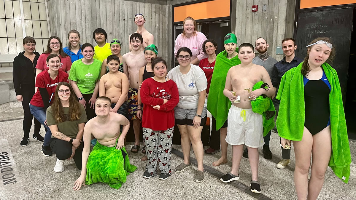 Group of swimmers posing out of the pool