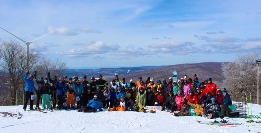 Large group of skiiers posing on snowny mountain